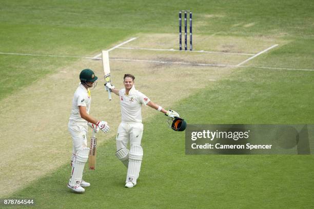 Steve Smith of Australia celebrates after reaching his century with team mate Pat Cummins of Australia during day three of the First Test Match of...