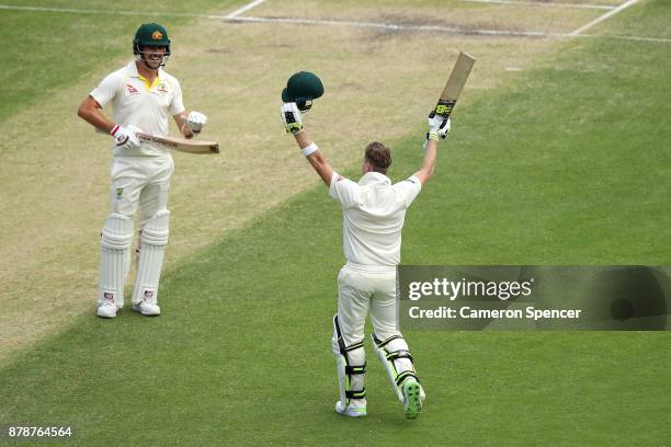Steve Smith of Australia celebrates after reaching his century with team mate Pat Cummins of Australia during day three of the First Test Match of...