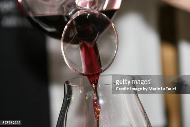 red wine pouring from a decanter to a wine glass - merlot ストックフォトと画像