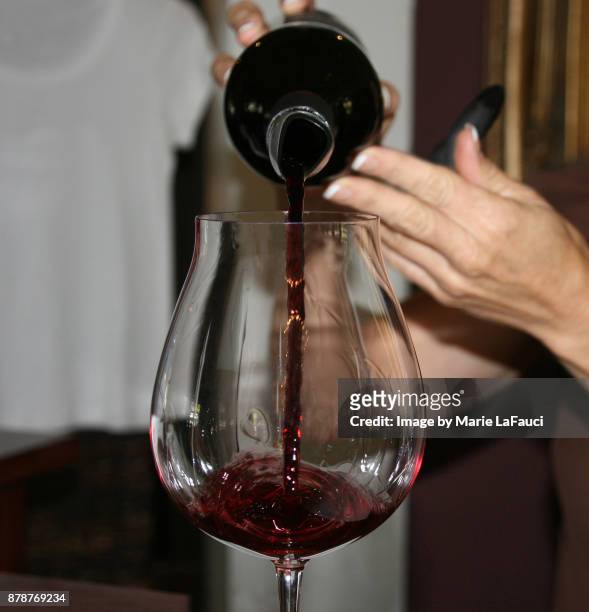 woman pouring red wine - wine glass finger food stock-fotos und bilder