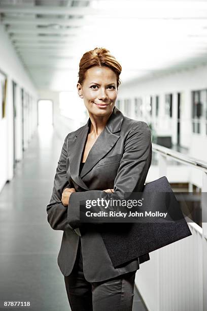 business woman holding a file, smiling - arrogant stock-fotos und bilder