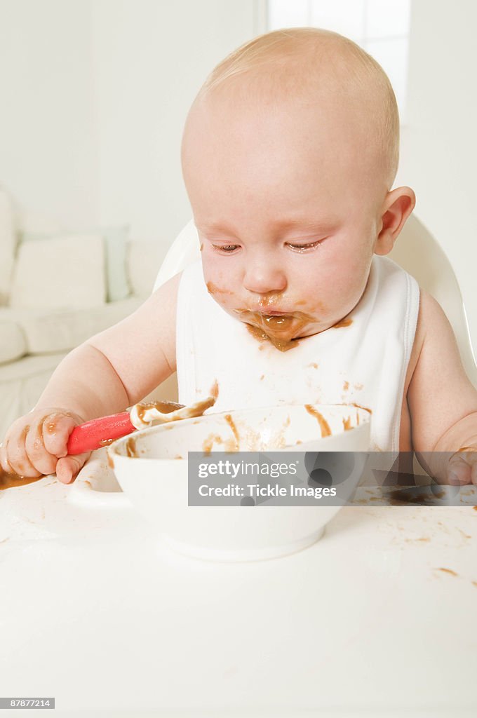 A portrait of a baby eating his food.