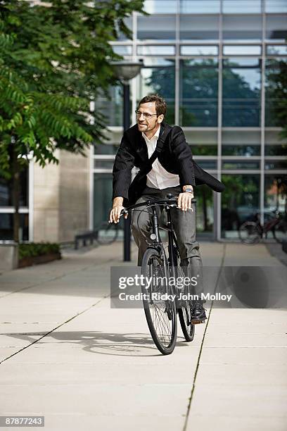 man leaving the office on bicycle - business person driving stockfoto's en -beelden