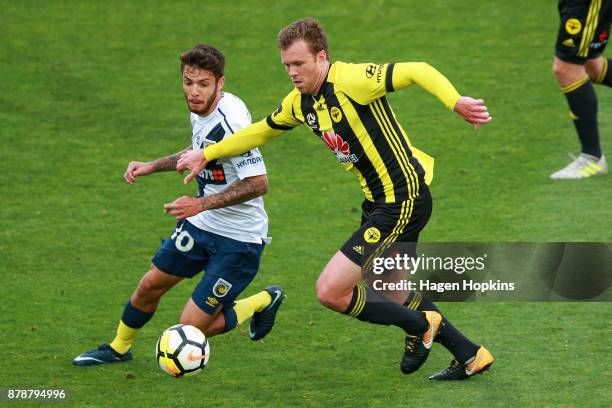 Michael McGlinchey of the Phoenix and Storm Roux of the Mariners compete for the ball during the round eight A-League match between the Wellington...