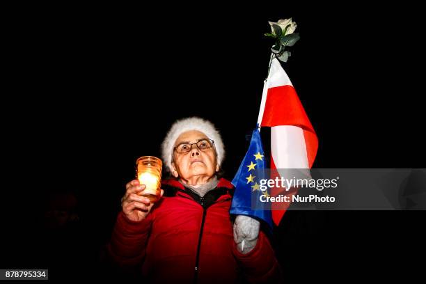 Woman holds Polish and EU flags during a protest at the Main Square against government plans for sweeping changes to Polands judicial system. Krakow,...