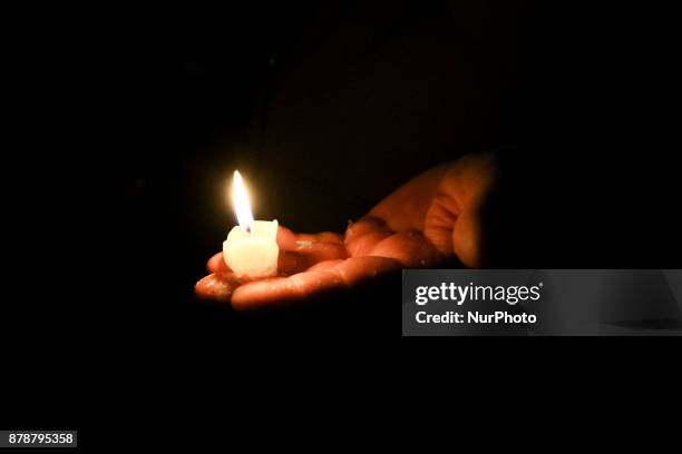 Person holds a candle during a protest at the Main Square against government plans for sweeping changes to Polands judicial system. Krakow, Poland on...
