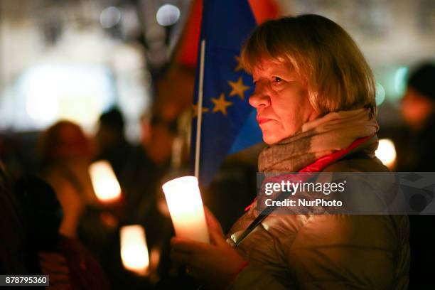 Woman holds a candle during a protest at the Main Square against government plans for sweeping changes to Polands judicial system. Krakow, Poland on...