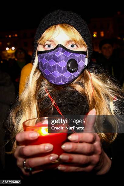 Woman wearing an anti-smog mask holds a candle during a protest at the Main Square against government plans for sweeping changes to Polands judicial...