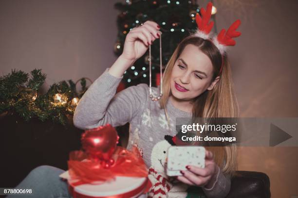 young woman enjoying christmas and opening presents - jewelry stock pictures, royalty-free photos & images