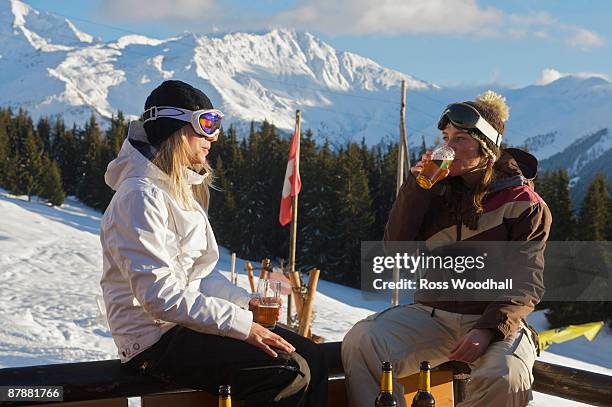 girl snowboarders having apres beers - verbier ストックフォトと画像