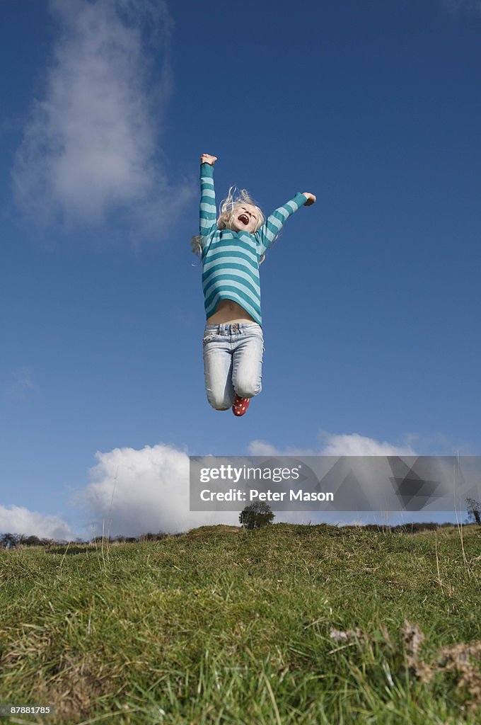 Girl jumping on hill