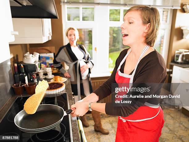 pregnant women making pancakes - pancake toss stock-fotos und bilder