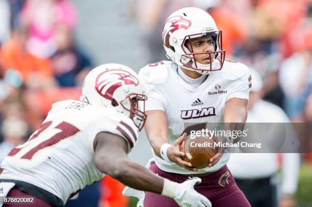 Quarterback Caleb Evans of the Louisiana Monroe Warhawks looks to hand the ball off to running back Derrick Gore of the Louisiana Monroe Warhawks...