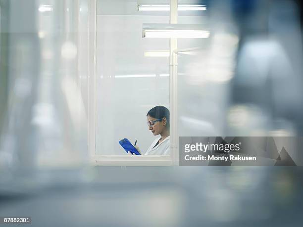 laboratory technician in window - clean suit stock pictures, royalty-free photos & images