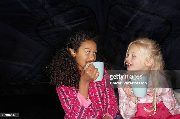 girls with hot drink in tent - nur mädchen stock-fotos und bilder