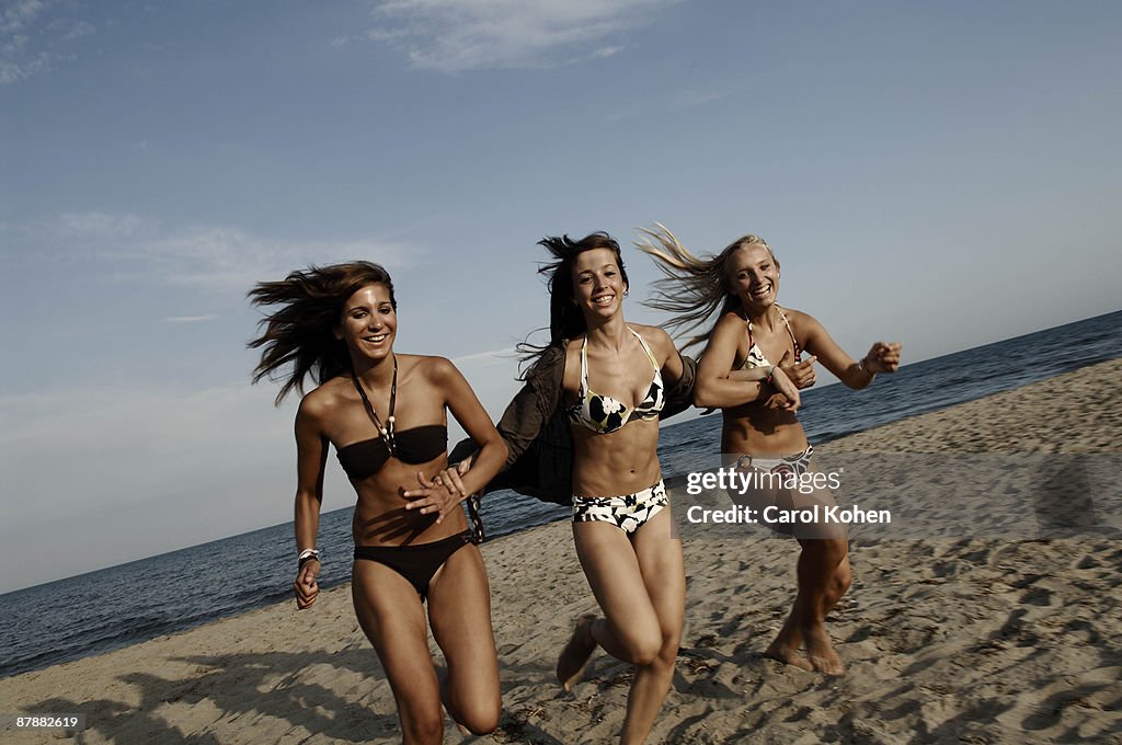 Girl teenagers running on the beach