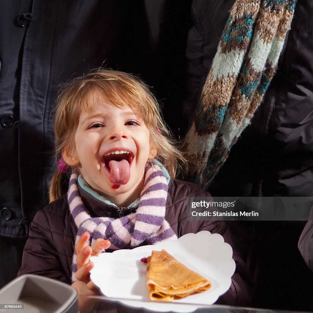 Girl eating crepe with jam