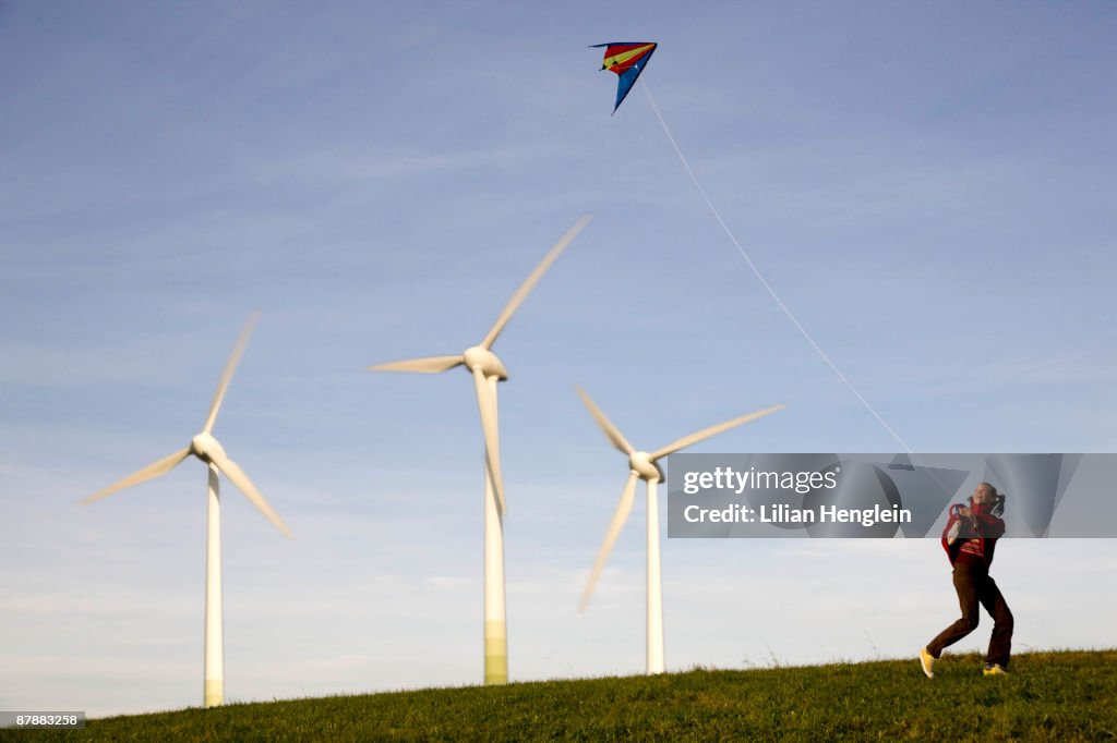 Girl Flying Kite at Wind Turbines