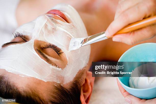 woman is getting a face mask - beautiful women spreading stock-fotos und bilder