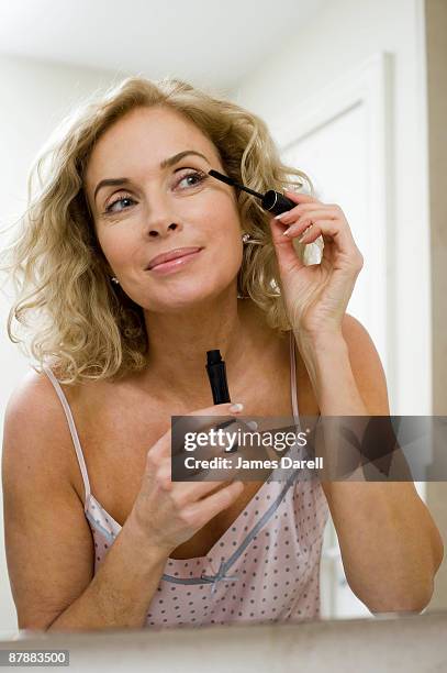 woman doing make up - mascaras 個照片及圖片檔