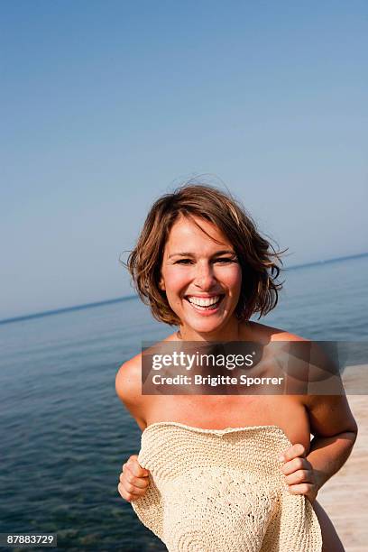 woman holding hat in front her - halbbekleidet stock-fotos und bilder