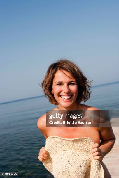 woman holding hat in front her - lättklädd bildbanksfoton och bilder