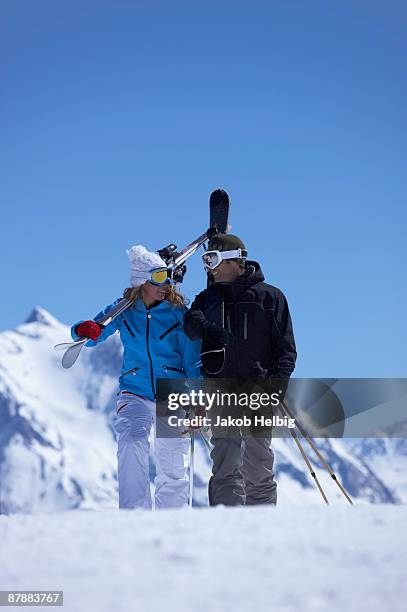 couple walking with skis over shoulder - savoie stock pictures, royalty-free photos & images