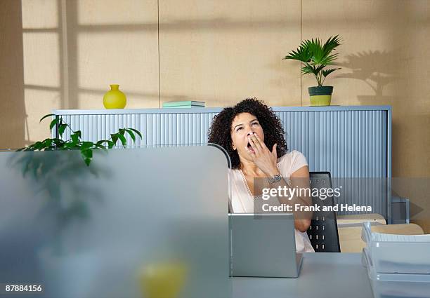 woman yawning at desk in office - overdoing stock pictures, royalty-free photos & images