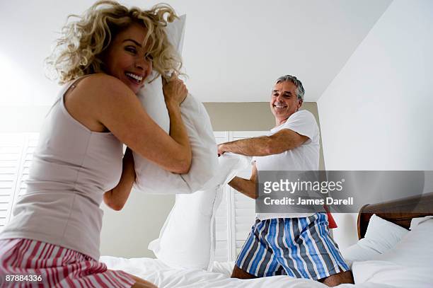 man and woman pillow fighting - pillow fight fotografías e imágenes de stock