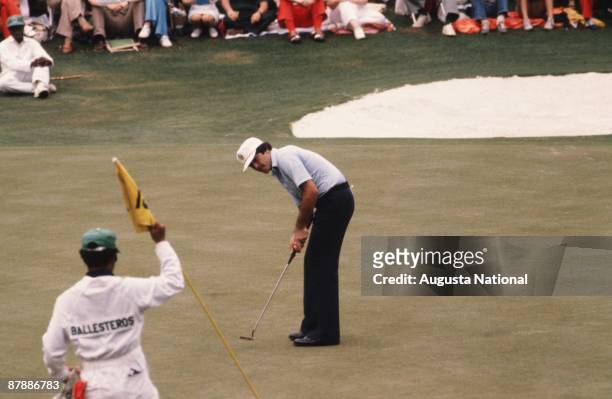 Masters Champion Seve Ballesteros watches his putt as his caddie holds the flag during the 1980 Masters Tournament at Augusta National Golf Club in...