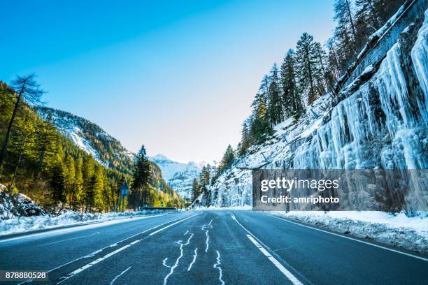 4 seasons - early onset of winter, country road with icicles in mountains - obertauern stock pictures, royalty-free photos & images