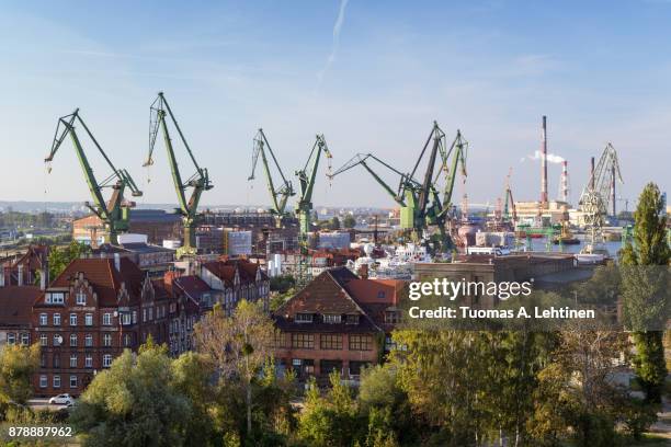 buildings and shipyard cranes in gdansk, poland, viewed from above on a sunny day. - gdansk stock pictures, royalty-free photos & images