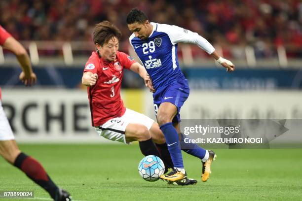 Urawa Red Diamonds' midfielder Tomoya Ugajin fights for the ball with Al Hilal's midfielder Salem al-Dawsari during the second leg of the AFC...