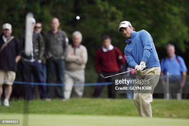 Northern Irish golfer Graeme McDowell chips onto the 1st green during the first day of the PGA Championship on the West Course at Wentworth, in...