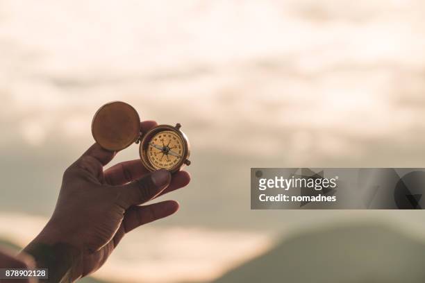 hand golding compass to navigate direction,travel direction discovery - história imagens e fotografias de stock