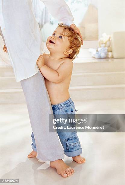baby standing up and holding to his mother leg - women with nice legs bildbanksfoton och bilder