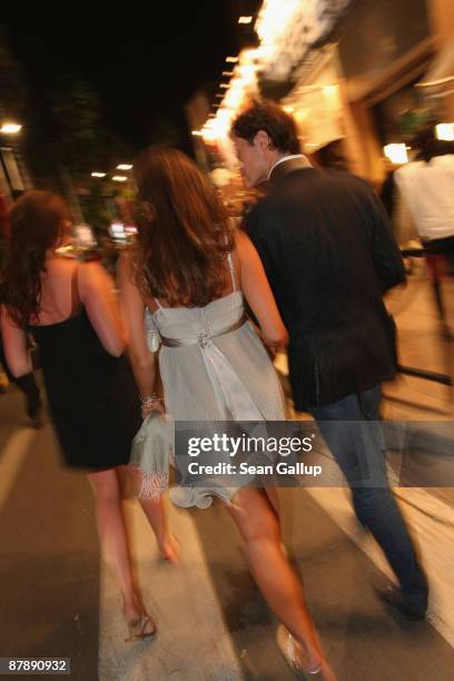 Man and two women dressed for a night out walk along the Croisette during the 62nd International Film Festival on May 18, 2009 in Cannes, France. The...