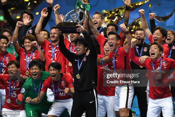 Head coach Takafumi Hori of Urawa Red Diamonds lifts the AFC Champions League trophy at the award ceremony during the AFC Champions League Final...