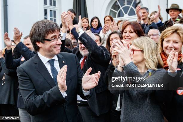 Deposed Catalan leader Carles Puigdemont applauds as he unites to pose with his fellow candidates after a press conference in Oostkamp, near Brugge,...