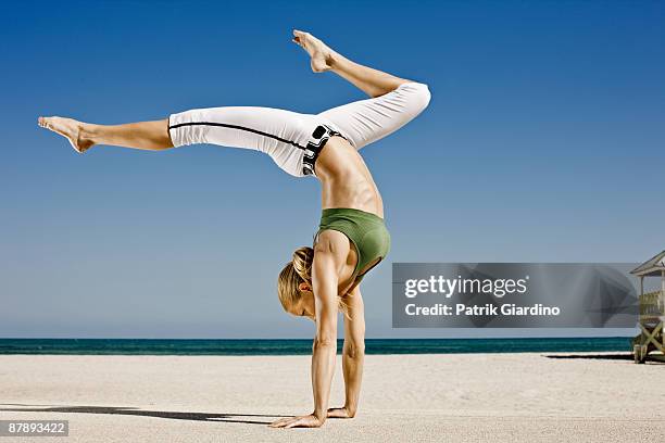 female athlete stretching, workout on the beach. - handstand beach photos et images de collection