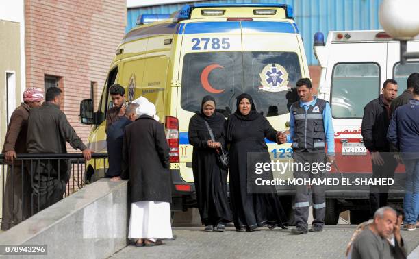 Relatives of the victims of the bomb and gun assault on the North Sinai Rawda mosque walk past an ambulance while waiting outside the Suez Canal...