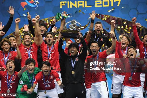 Head coach Takafumi Hori of Urawa Red Diamonds lifts the AFC Champions League trophy at the award ceremony during the AFC Champions League Final...