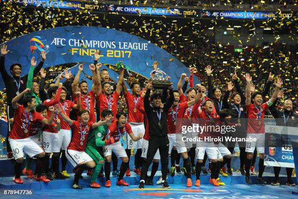 Head coach Takafumi Hori of Urawa Red Diamonds lifts the AFC Champions League trophy at the award ceremony during the AFC Champions League Final...