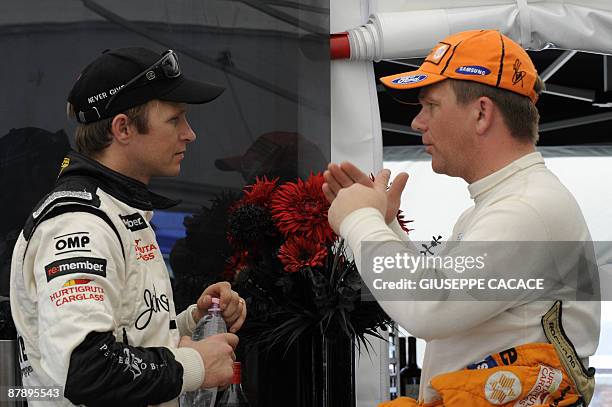 Norwegian Petter and Henning Solberg chat during the shakedown stage of the WRC Italian auto rally 2009 on May 21, 2009 in Olbia, Sardinia. The World...