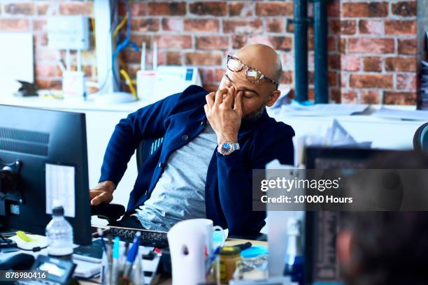 man sitting in modern office - fatigué photos et images de collection