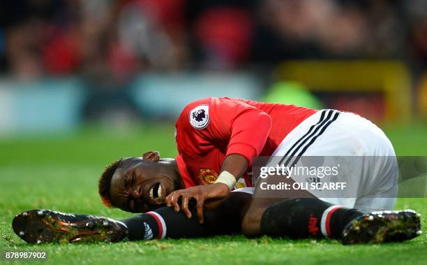 Manchester United's French midfielder Paul Pogba reacts on the pitch with an injury during the English Premier League football match between...