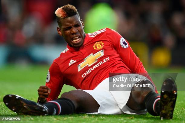 Manchester United's French midfielder Paul Pogba reacts on the pitch with an injury during the English Premier League football match between...