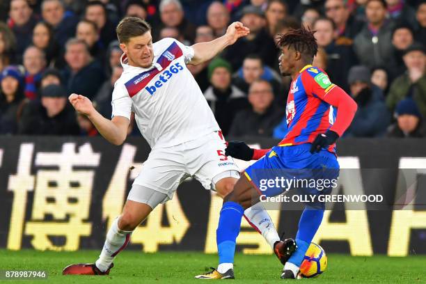 Stoke City's Austrian defender Kevin Wimmer makes a painful challenge on Crystal Palace's Ivorian striker Wilfried Zaha during the English Premier...