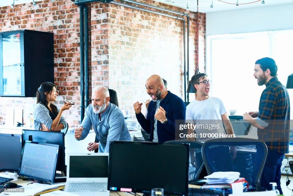 People cheering in modern office