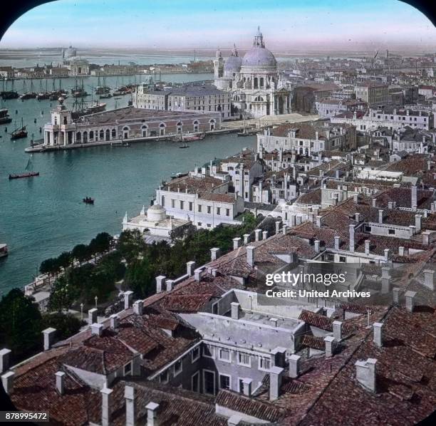 From the top of the bell tower we see over the next rooftops to the beginning of the great canal, the richly decorated church Maria della Salute with...
